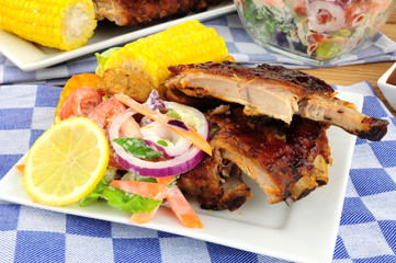 Barbecued pork ribs meal with sweetcorn and fresh salad