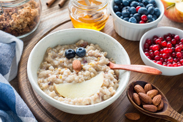 Meal for kids - oatmeal porridge bowl with cute funny face made with fruits. Cozy breakfast food