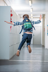 boy jumping in school corridor
