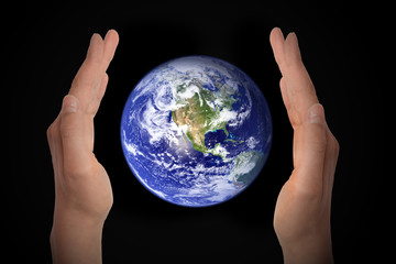 Glowing earth globe in hands on black background, environment concept - elements of this image furnished by NASA