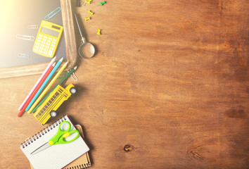 Notebook with school supplies on a wooden background