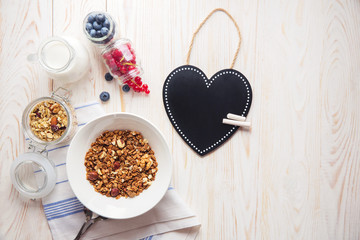 Morning healthy breakfast homemade baked granola or muesli with fresh blueberries white background with heart's boarder for notes