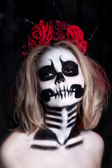 Portrait of young woman with scared halloween makeup over black background