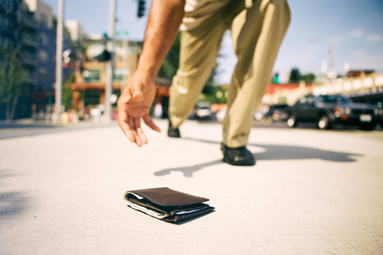 Wallet: Man Stoops Over To Pick Up Dropped Wallet