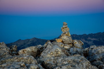 Amazing purple sky at sunset on a mountain top in Bulgaria with a small stone pyramid in the foreground