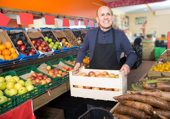 engaged mature male vendor in grocery store
