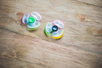 Colored fidget spinners stress relieving toy on wooden background