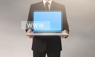  business man and suit holding laptop in hands