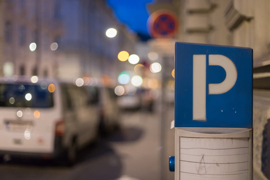 Parkplatz Symbol, Straßenrand mit parkenden Autos