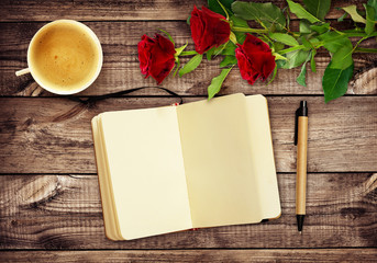 Naklejka na ściany i meble Wooden desk with notepad, pen, cup of coffee and red rose flowers