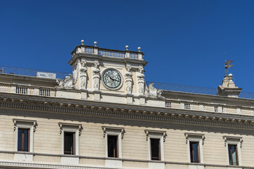 Fototapeta na wymiar Antique clock on facade of an old classic building in Rome, Italy. Decoration with elegant architectural details