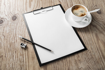 Clipboard with blank letterhead, coffee cup, pencil and sharpener on wooden background. Mock up for your design. Responsive design template.