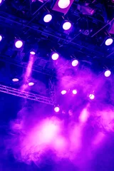 Acrylic prints Light and shadow Purple light rays from the spotlight through the smoke at the theater or concert hall. Lighting equipment for a performance or show.