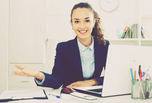 Business lady sitting at office desk with laptop