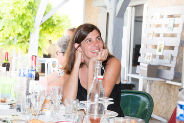 leisure, holidays, eating, people and food concept - happy friends having dinner at summer garden party