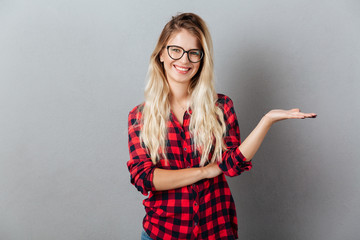 Emotional smiling young blonde woman holding copyspace