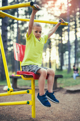 Fototapeta na wymiar Boy with exercise machines in the park