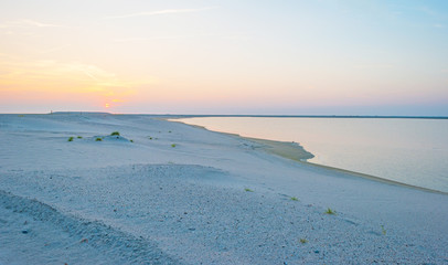 Artificial island under construction in a lake at sunset in summer