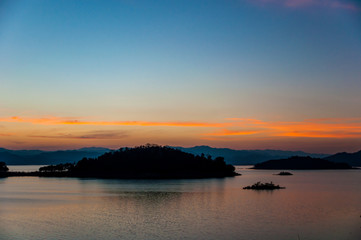 Landscape view of tranquil mountain and lake at sunset