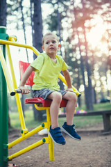 Boy with exercise machines in the park