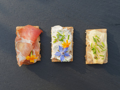 Snacks dekoriert mit frischen Kr&auml;utern auf Schiefertafel