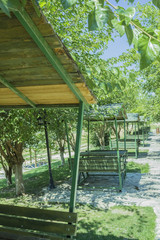 Series of green bench huts in a sunny outdoors park