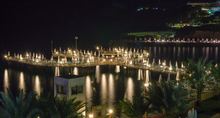 Pier, dock in the sea, lit by the light of the street lamps