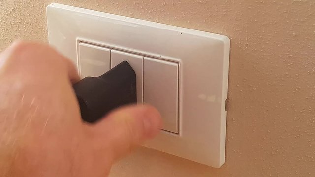 Man plugging the plug into the electrical socket