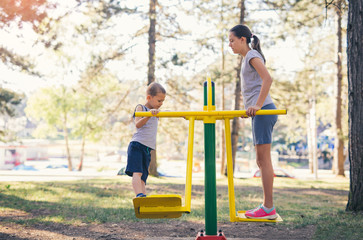 Obraz premium Brother and sister workout outdoors in a park with exercise machines