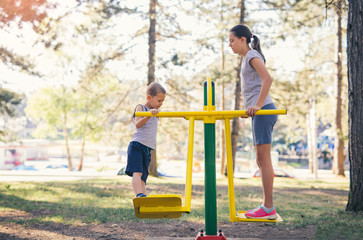 Brother and sister workout outdoors in a park with exercise machines