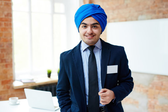 Young Office Worker In Suit And Blue Turban Standing In Front Of Camera