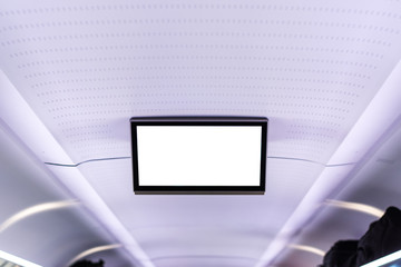 A blank white info screen on the ceiling in a train