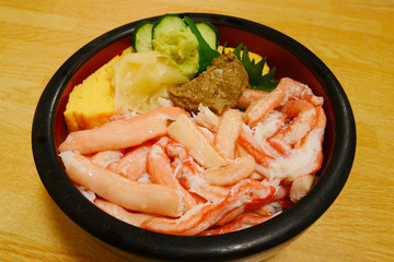 Kanidon japanese crab bowl with kanimiso and sweet egg in red black bowl on wooden background.