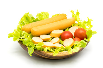 Sausages, lettuce and tomatoes in wooden bowl
