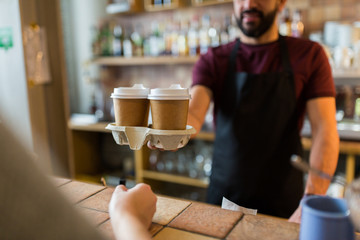 man or bartender serving customer at coffee shop