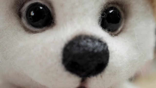 Soft toy of wool (felt) handmade: white bear cub, teddy bear. A popular toy on a light background, close-up. The concept of needlework, collectible toys, hobbies. Causes tenderness
