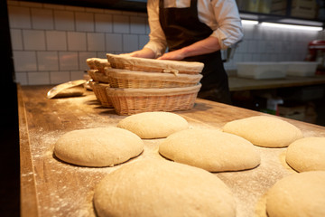 baker with baskets for dough rising at bakery