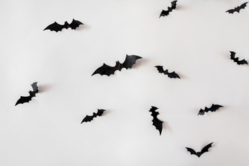 black paper bats over white background