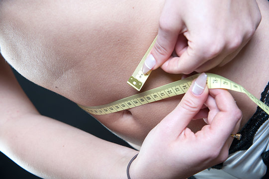 frau misst Bauchumfang