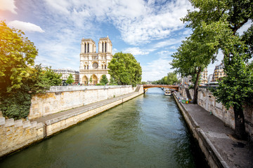 Fototapeta na wymiar Cityscape view on Notre Dame basilica with water channel during the sunny day in Paris
