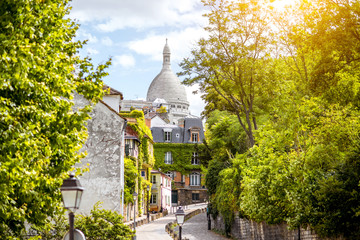 Cityscape view on the beautiful street with Sacred Heart cathedral on Monmartre hill in Paris - obrazy, fototapety, plakaty