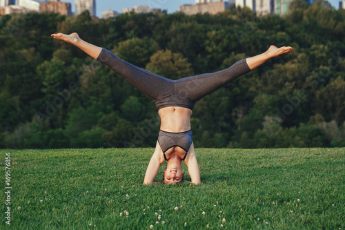 "Young beautiful Caucasian woman doing headstand yoga pose. Yogi woman