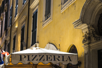 Old cozy street in Rome, Italy and typical Italian pizzeria. Architecture and landmark of Rome