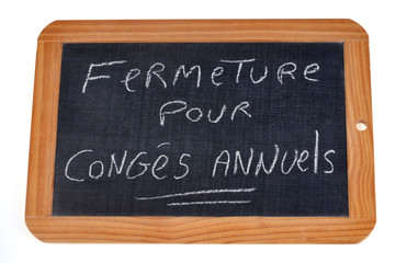 Obraz premium Ardoise sur laquelle est écrit fermeture pour congés annuels