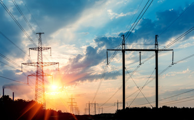 power transmission tower silhouetted against the sunset glow.