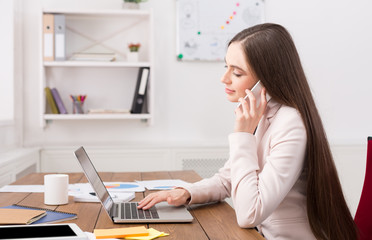 Obraz na płótnie Canvas Serious business woman at work talking on phone