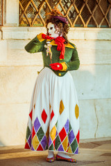 A masked woman with a puppet at the Venice Carnival.