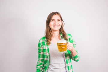 Cheerful young woman holding a beer mug full of beer and smiling on white background