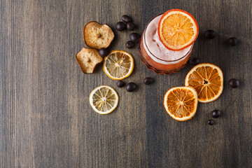 Obraz na płótnie Canvas Orange cocktail with citron on wooden background