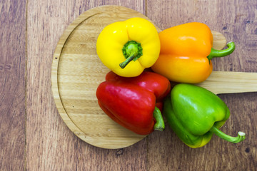 Four different colored bell peppers top view